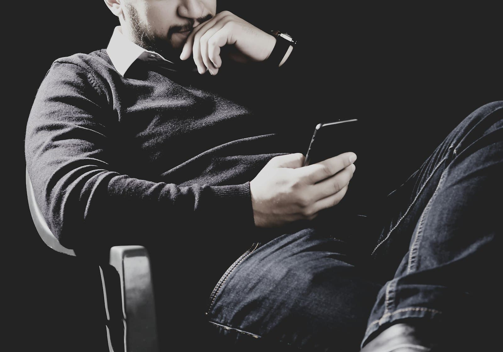 A person reading threads on a phone in low light
